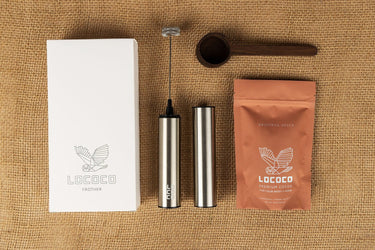 Original Spice Cocoa Kit laid out on burlap: the frother box, the frother, a wooden scoop and a bag of Original Spice cocoa