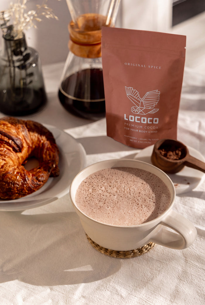 A cup of LOCOCO next to a pour-over coffee